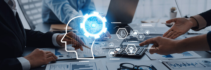 A business team engages in a discussion about artificial intelligence, utilizing digital graphics and charts to emphasize innovation and teamwork in a modern workspace. Trope