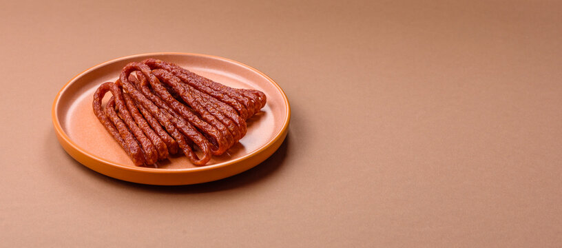 Smoked cabanossi, thin salami sausage, meat sticks, or snacks. Cabanossi sausage - Powered by Adobe