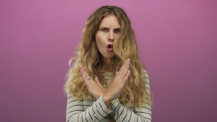 Woman arms crossing studio blonde young stop serious pink denial scene conveys clear refusal.