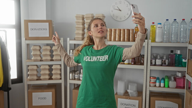 Woman uses hand to take selfie in a warehouse volunteer donation setting, smiling with blonde hair and young face against shelves. - Powered by Adobe