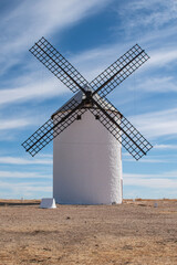A windmill in La Mancha, isolated on land in Campo de Criptana, Ciudad Real province, Spain.
