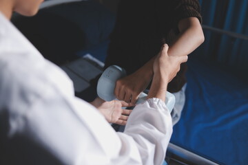 Fototapeta premium Old woman training with physiotherapist using dumbbells at home. Therapist assisting senior woman with exercises in nursing home. Elderly patient using dumbbells with outstretched arms.
