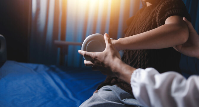 Old woman training with physiotherapist using dumbbells at home. Therapist assisting senior woman with exercises in nursing home. Elderly patient using dumbbells with outstretched arms. - Powered by Adobe