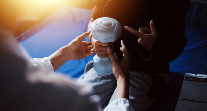 Old woman training with physiotherapist using dumbbells at home. Therapist assisting senior woman with exercises in nursing home. Elderly patient using dumbbells with outstretched arms.