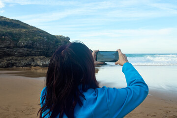 Woman photographer on the beach of Tayrona National Park (Magdalena, Colombia) on May 11, 2016.
