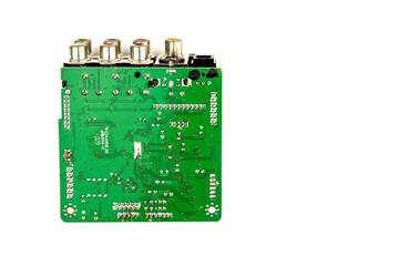A green printed circuit board from an electrical appliance or computer, photographed close-up on a white background. Electronics concept