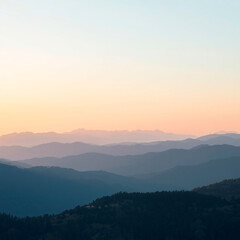 Fototapeta premium Serene Mountain Landscape at Sunrise with Soft Haze
