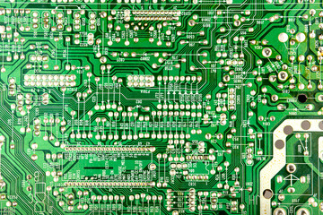 A close-up of a green printed circuit board from an electrical appliance or computer. Concept of electronics and microprocessor technology