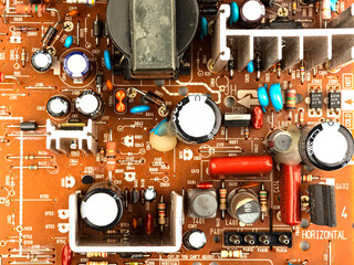 A close-up of a brown printed circuit board from a computer or electronic device. Concept of electronics