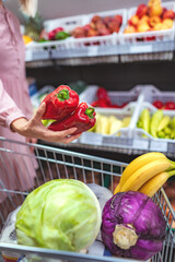 Woman buying fresh red peppers for healthy diet