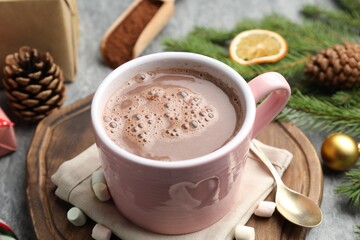Tasty cocoa, marshmallows and Christmas decor on grey table, closeup