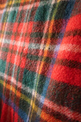 Obraz premium Red and green tartan wool fabric close up showing texture and traditional Scottish plaid pattern background