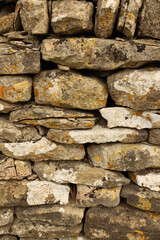 Dry stone wall texture with weathered stones and colorful lichen, natural rustic background pattern