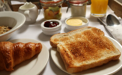 Serving a fresh continental breakfast spread with various delicacies on a white tablecloth. Cotswolds countryside, England