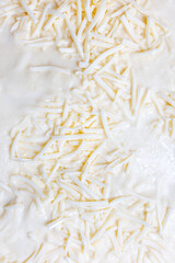 Close-up texture of shredded white cheese