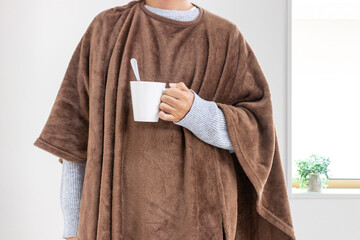 着る毛布を着てコーヒーを飲む男性（30代、日本人、顔無し）