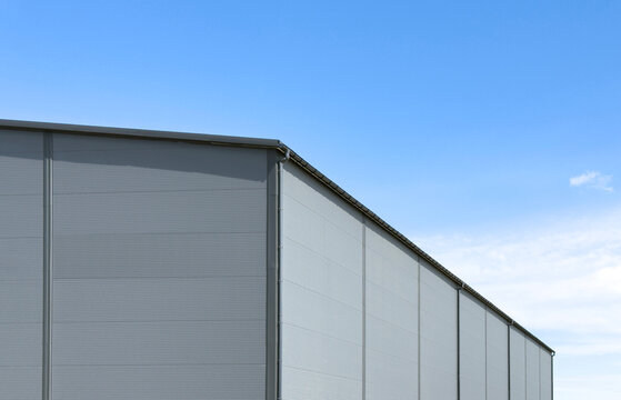Gray sandwich-panel warehouse facade with gutter