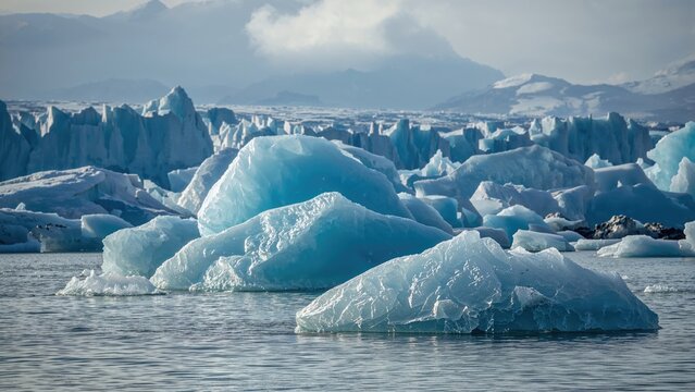 Icebergs and glaciers in polar seawater with snow-covered mountains in the background. Natural arctic landscape. Polar and glacial environment. Cold and icy scenery.