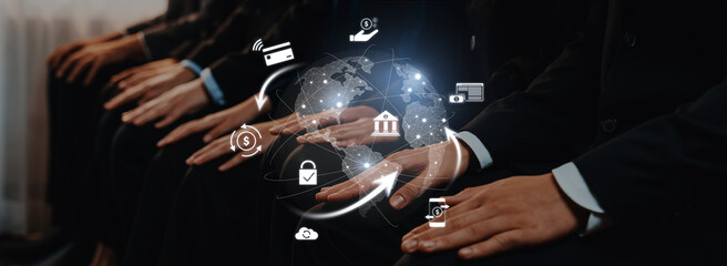 Business professionals sit together with hands positioned, surrounded by digital finance icons, illustrating global connections in financial services and technology. Trope