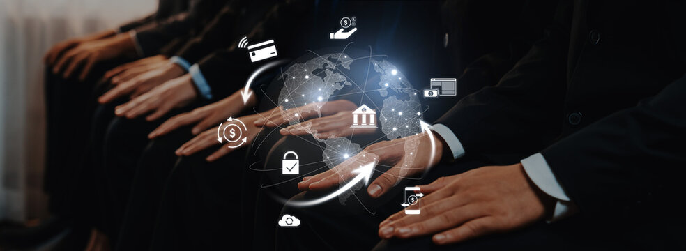Business professionals sit together with hands positioned, surrounded by digital finance icons, illustrating global connections in financial services and technology. Trope