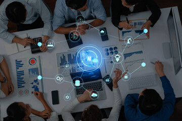 Business team collaborates on artificial intelligence strategies using charts and technology icons, highlighting teamwork and innovation in a modern workspace. Trope