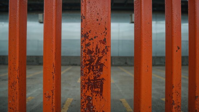 Iron bars on a gate or fence with rusty patches, close-up view. Urban security and barrier concept. The image emphasizes corrosion and age of the metal. - Powered by Adobe