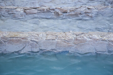 Clear blue water flowing in a decorative fountain. A calm and refreshing scene capturing the soft movement of water and the bright turquoise color.