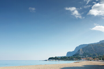 Bright Beach Scene With Calm Sea, Clear Sky, And Distant Pier At Sunset-Ready Landscape Stock Photo