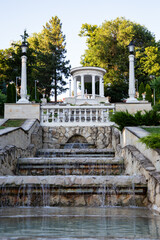 Terraced Fountain and Lake View in a Green Park, Moldova. Soft sunlight highlights the stone architecture and peaceful landscape. Perfect for travel, tourism, nature, and outdoor scenery concepts.