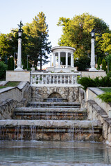 Terraced Fountain and Lake View in a Green Park, Moldova. Soft sunlight highlights the stone architecture and peaceful landscape. Perfect for travel, tourism, nature, and outdoor scenery concepts.