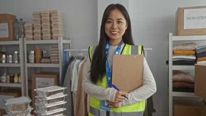 Woman wearing a reflective vest in a charity center with donations and packages, exemplifying volunteer work indoors, all within a neatly arranged room environment.