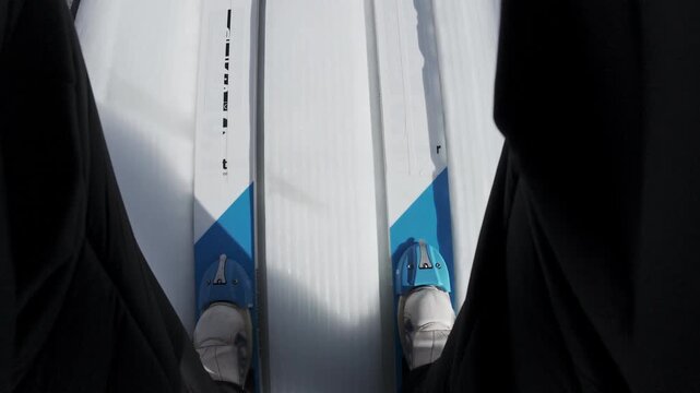 Ski jumper on the skis sliding down a jumping ramp, achieving an explosive jump, flying and landing gently and safely on snow, point of view shot.