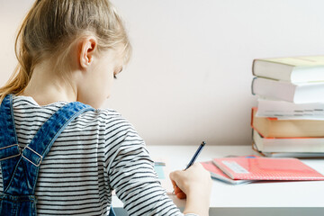 Teenager studying and doing her homework while holding pen with copy space