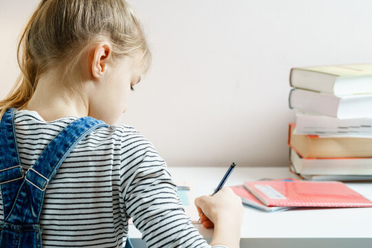 Teenager studying and doing her homework while holding pen with copy space - Powered by Adobe