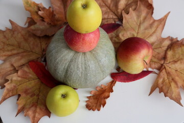 Pumpkin and apples laying  on the table