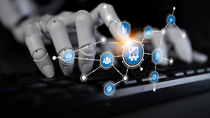 A robotic hand engages with a computer keyboard, highlighting the intersection of technology and artificial intelligence in a modern workplace setting. Tessel