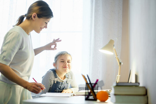 Mother and daughter doing homework together, styding and learning concept, doing tasks for school