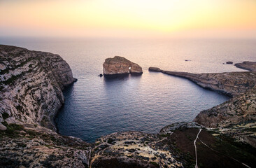 Scenic sunset view over the coastline of Gozo Malta highlighting majestic cliffs and calm waters