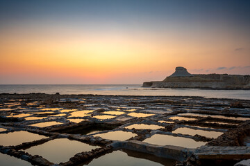 Sunrise over Malta salt pans with reflections and tranquil waters