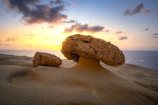 Mushroom Rock stands tall against the sunset in Malta's coastal landscape - Powered by Adobe