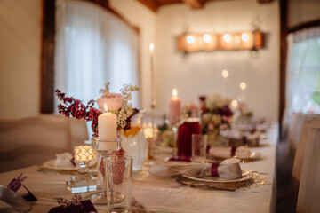 Elegant dining table set for a special occasion, adorned with candles, flowers, and decorative elements, creating a warm and inviting atmosphere for gatherings