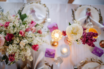 Elegant table setting with floral centerpiece, candles, and decorative plates, creating a romantic atmosphere for a special occasion or celebration with copy space