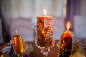 Elegant arrangement of decorative candles in glass holders, featuring warm colors and unique shapes, creating a cozy ambiance for festive celebrations and gatherings