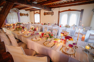 Elegant banquet setup with beautifully arranged tables adorned with floral centerpieces, candles, and fine dining ware, creating a romantic atmosphere for special occasions