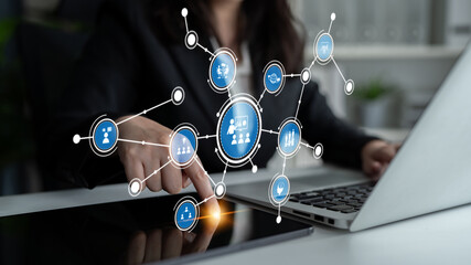A businesswoman engages with a digital network on her laptop, symbolizing innovation and data analysis in a modern office. Perfect for tech and business themes. Tessel