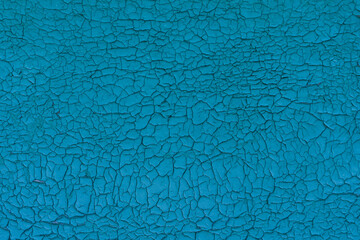 Old vintage cracked wall, blue pelling paint. Aged aquamarine flaky crackle surface.