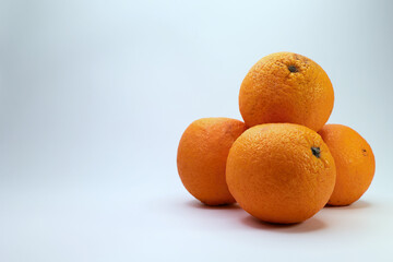 Several Ripe, Fresh Oranges Are Piled Together On A Clean White Surface, With Plenty Of Copy Space.