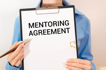 Office desk with paperwork and other objects and text Mentoring Agreement