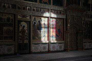 Altar inside an Orthodox church with warm sunlight falling on religious icons. The light highlights the details of the paintings and creates a serene, spiritual atmosphere.
