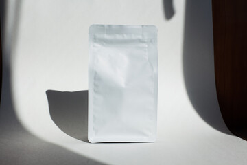 Blank craft plastic pouch, white pack on studio background with shadow, mylar bag isolated for coffee or food, cosmetic products, snack, candy. Different sizes, mock up.
